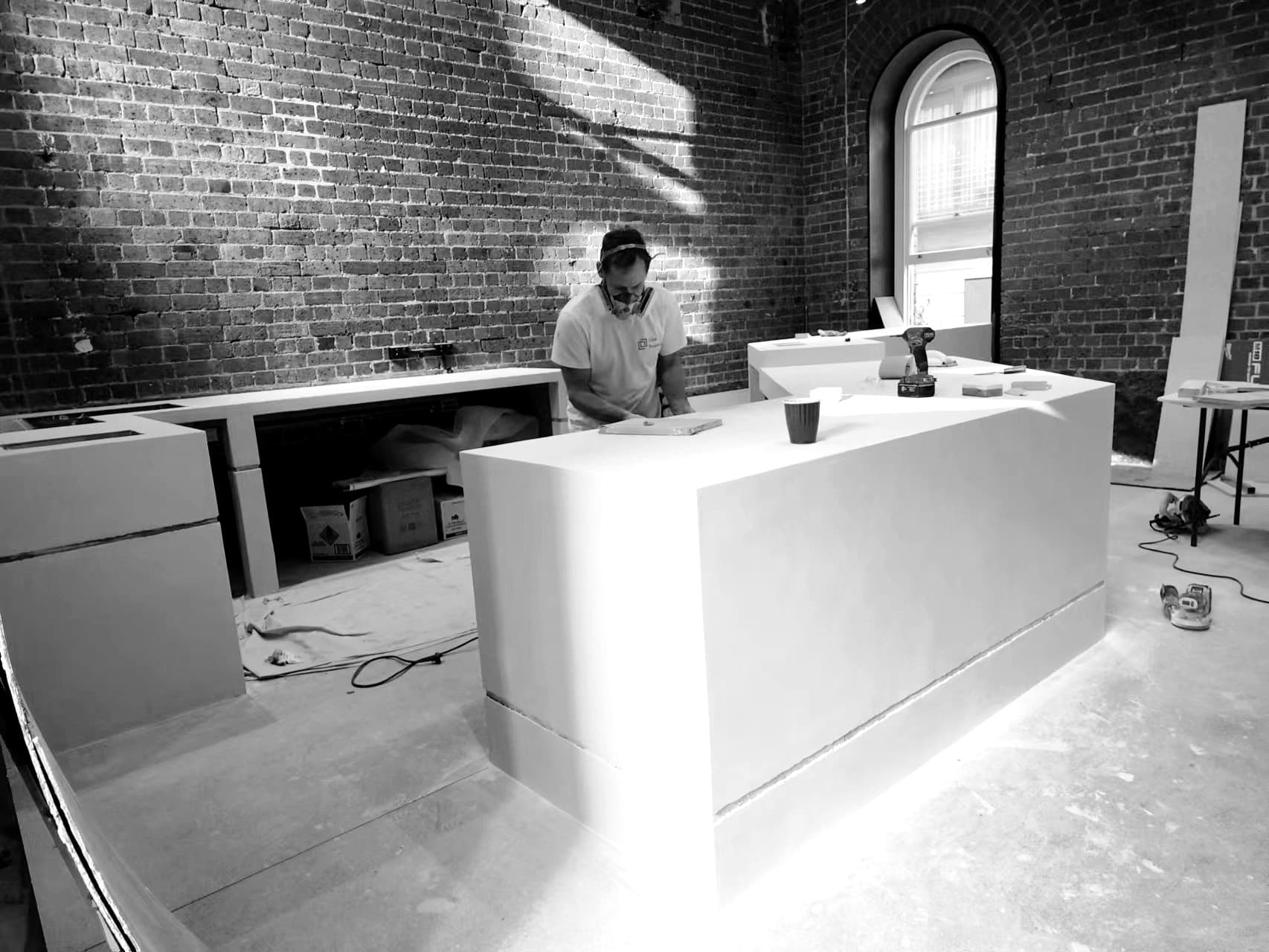 Microcement being finished by hand on a café counter